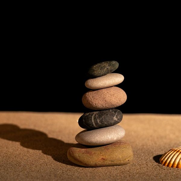 Stack of perfectly balanced stones on a wooden surface.